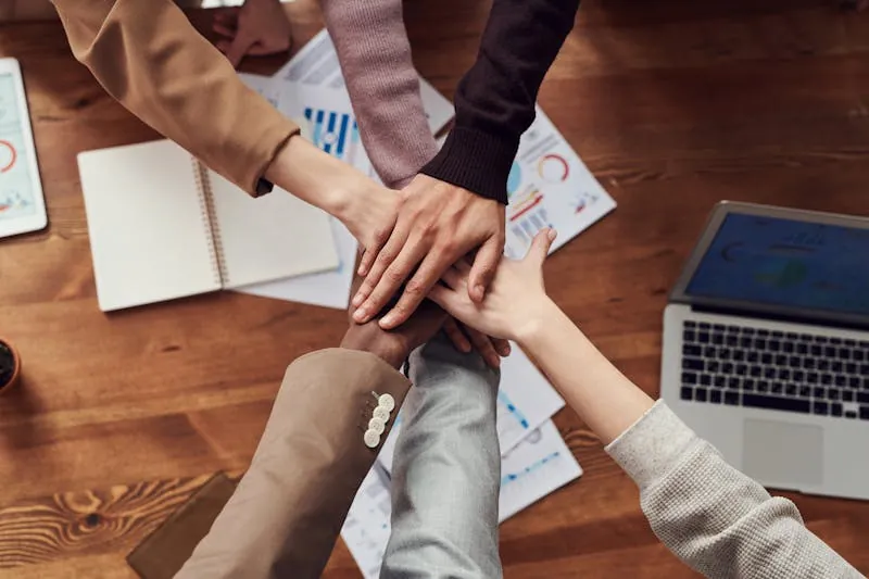 Coworkers stacking their hands together over a desk